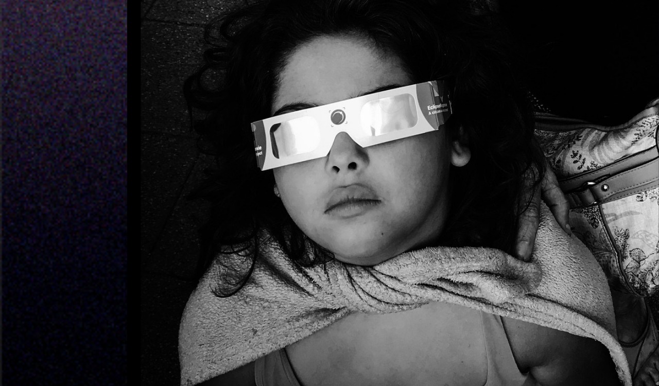 Girl looking through special glasses to view a solar eclipse
