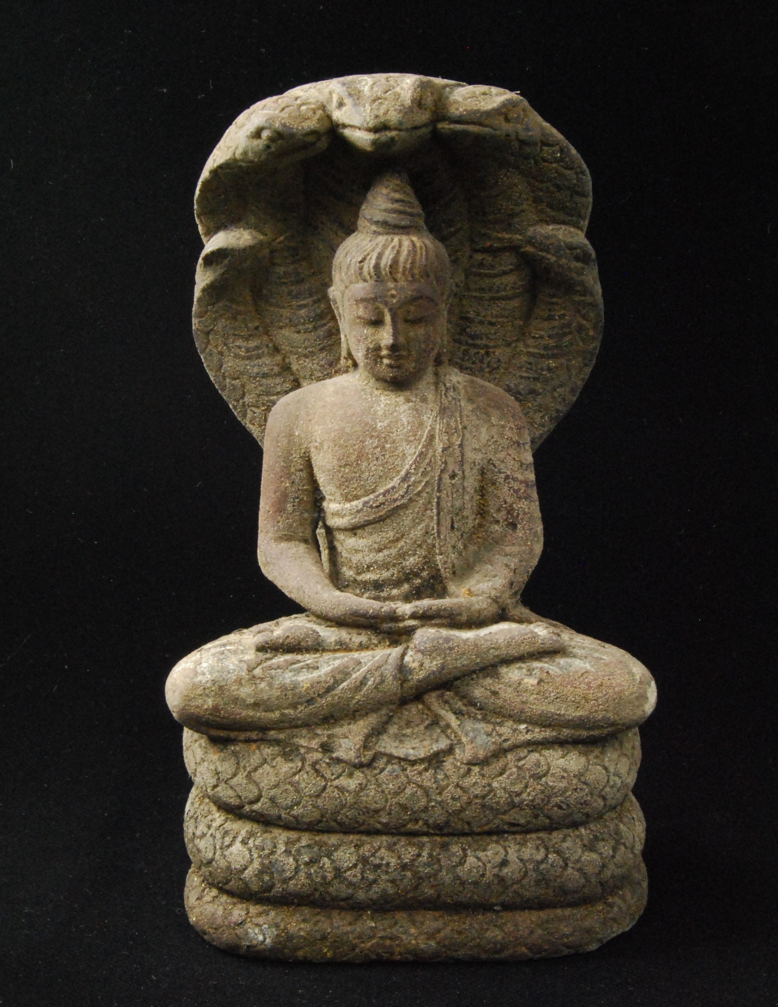 Sculpture figure in lotus pose with cobra hood behind the figure