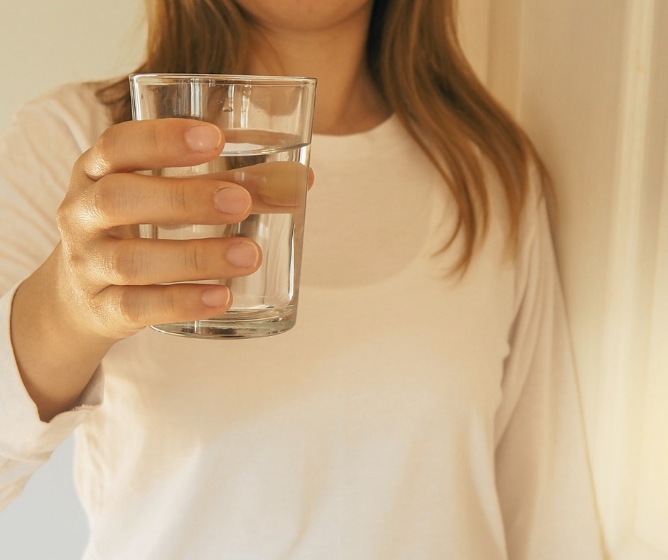 Woman holding glass of water